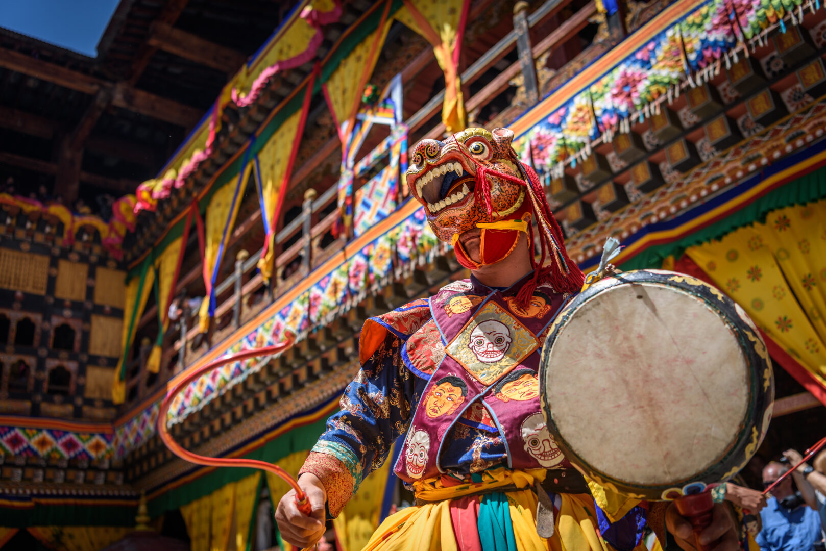 Monk in Bhutan dances wearing a traditional costume.