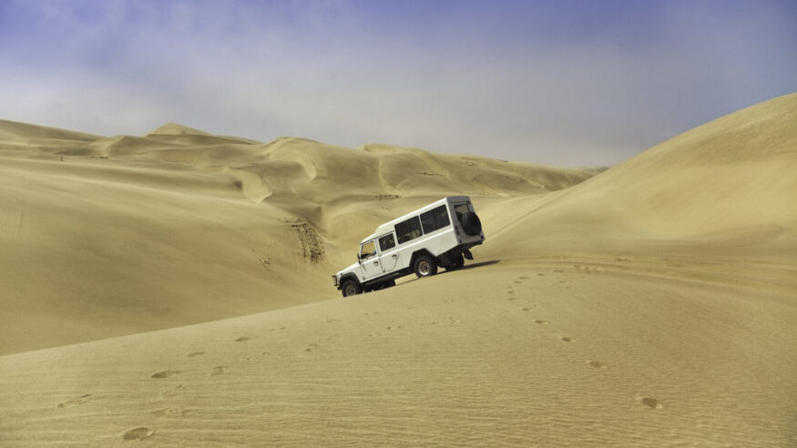 A four wheel drive vehicle descends the sand dunes between Walvis bay and Sandwich harbour.