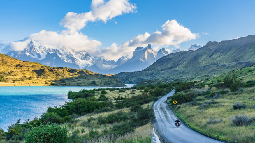 Beautiful panoramic view of stone road with aqua blue Pehoe lake and background of nature cuernos mountains peak with cloud in autumn, Torres del Paine national park, south Patagonia, Chile.