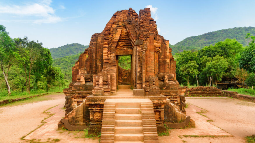 Wonderful view of red brick temple of My Son Sanctuary among green woods in Da Nang (Danang), Vietnam. My Son is a complex of partially ruined ancient Hindu temples constructed by the kings of Champa.