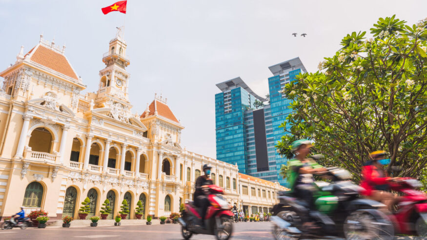 Ho Chi Minh City, Vietnam: Saigon City Hall, Vincom Center towers and colorful street traffic blurred in motion. Saigon downtown with its famous landmarks. Stock image with removed logos.