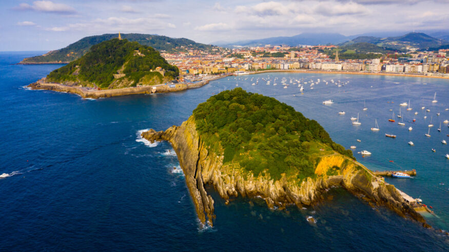 Picturesque aerial view of turquois water of La Concha Bay of San Sebastian with Santa Clara Island and moored pleasure yachts, Spain
